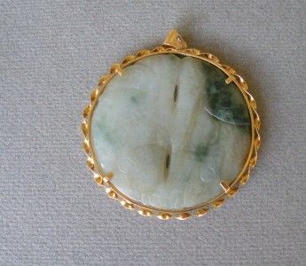 light colored jade pendant carved with 2 fish on either side. 12 